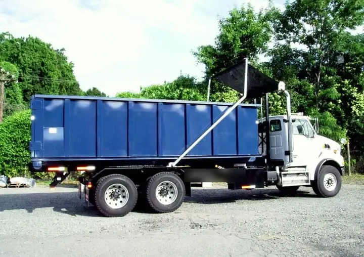 Roll-off truck carrying a dumpster